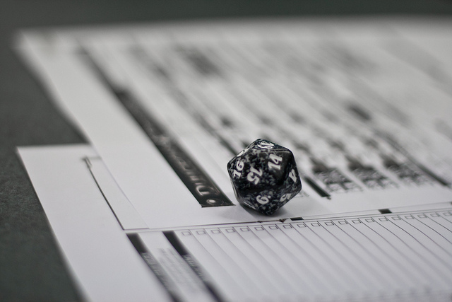 Двадцатигранная кость на листах персонажей D&D